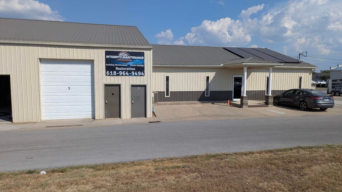 a photo of a commercial office and shop building with a sign on the side with information about the company.